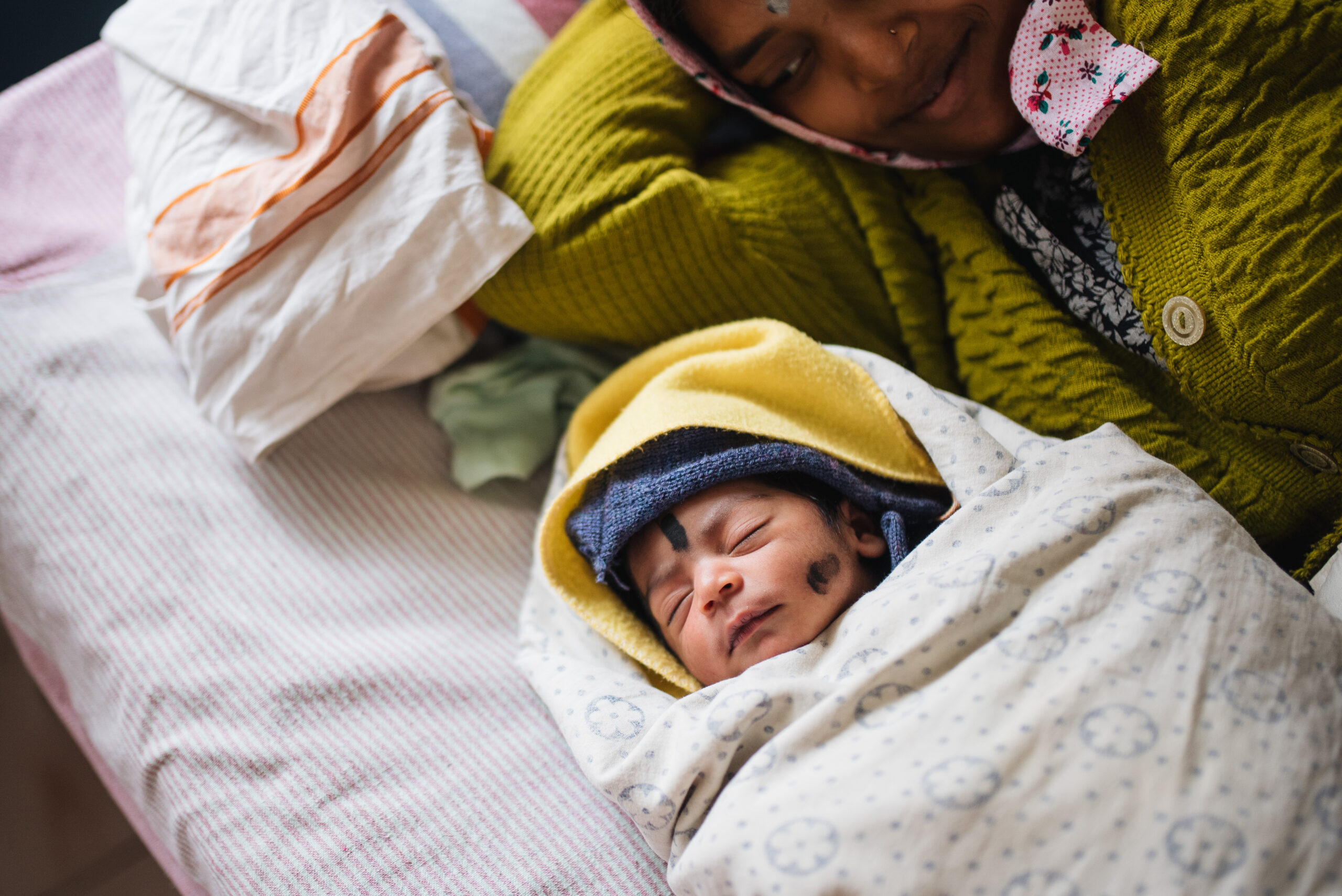 A mother holds her baby at Dasarahalli Referral Hospital, Karnataka