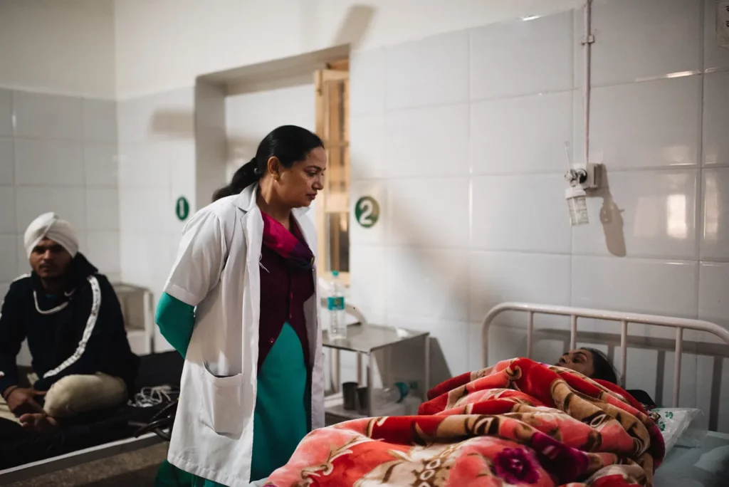 A nurse looks over a patient.