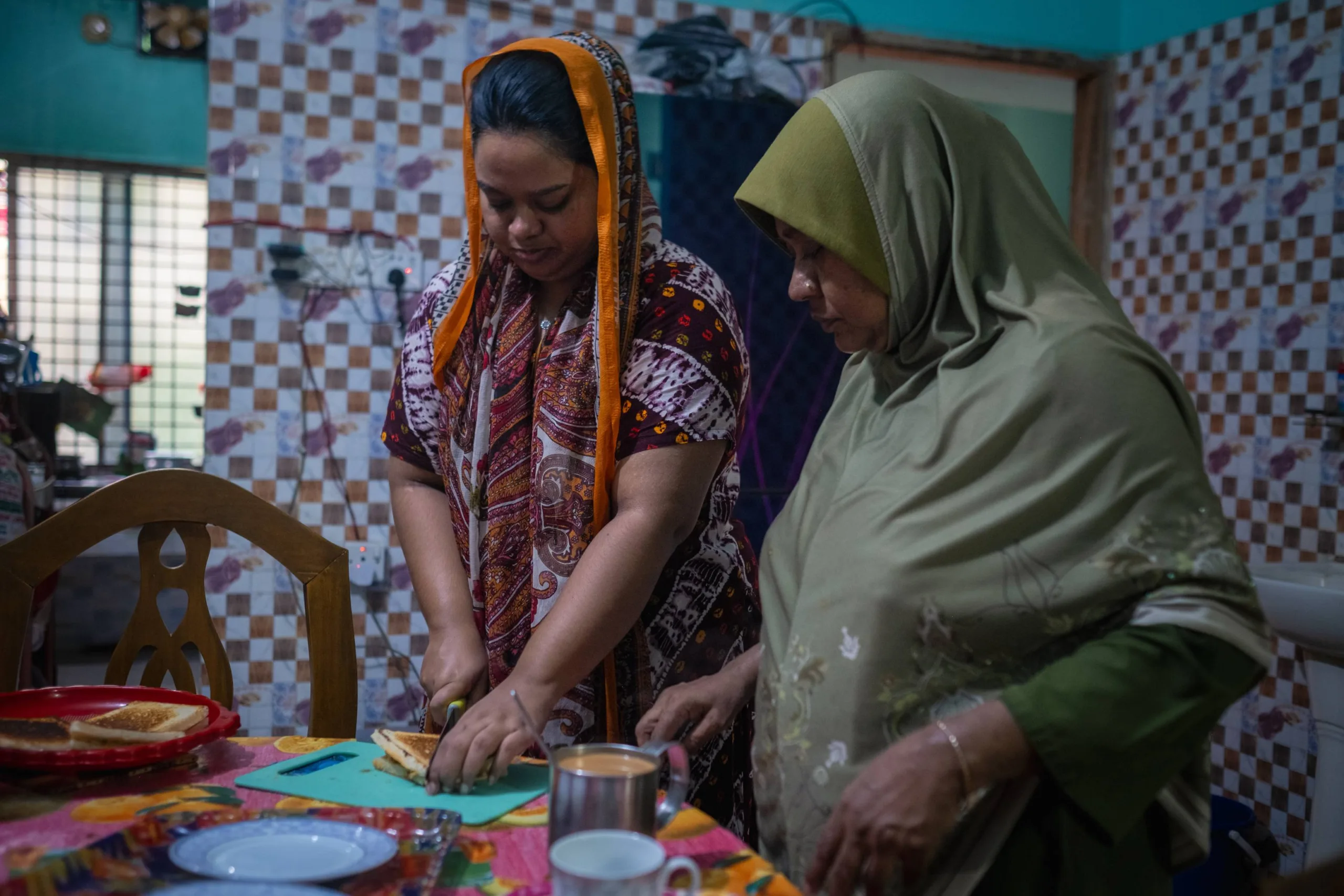 Mahamuda and her older daughter prepare their breakfast together. 