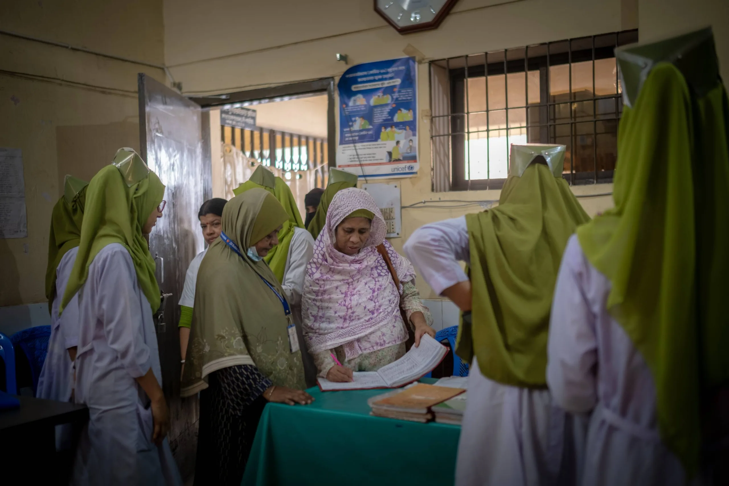 Mahamuda signs in at the nursing station, alongside her fellow nurses. 