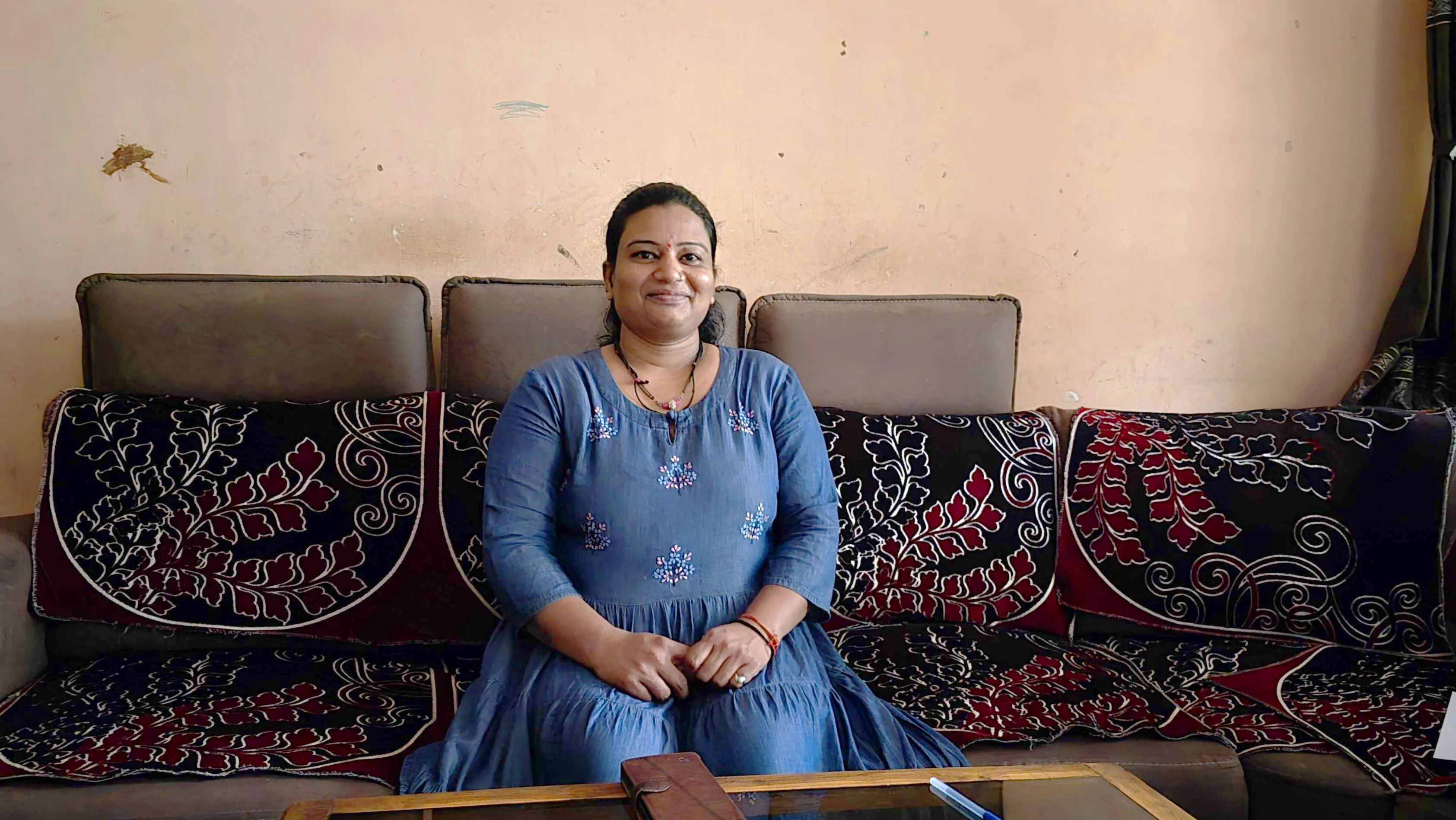 Caregiver and patient Archana More sits in her home.