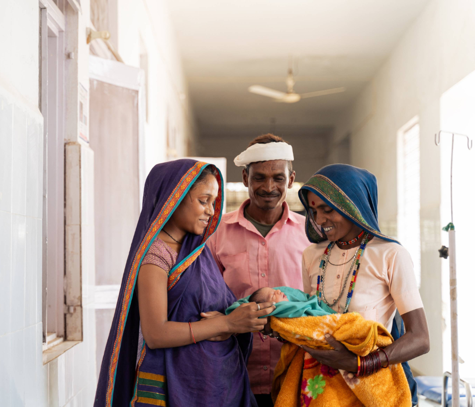 A man and two women hold their newborn baby at a community health center in Madhya Pradesh, India.