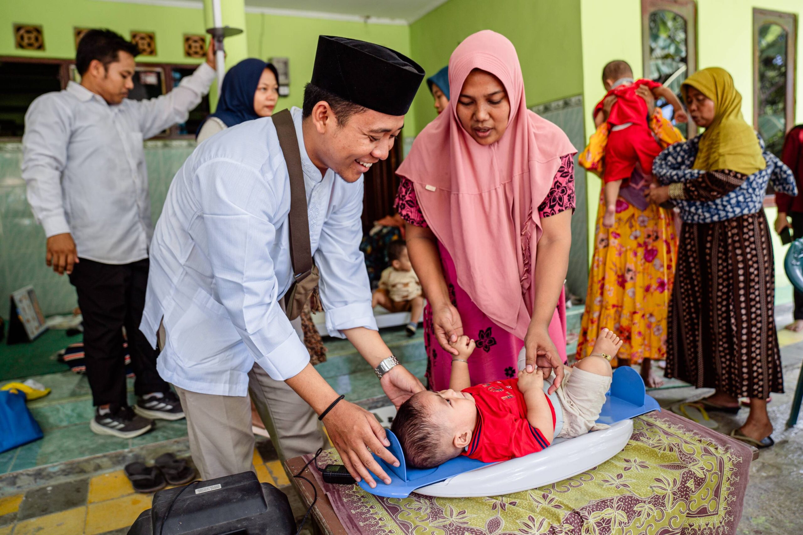 A baby's growth is measured at a posyandu in Indonesia.