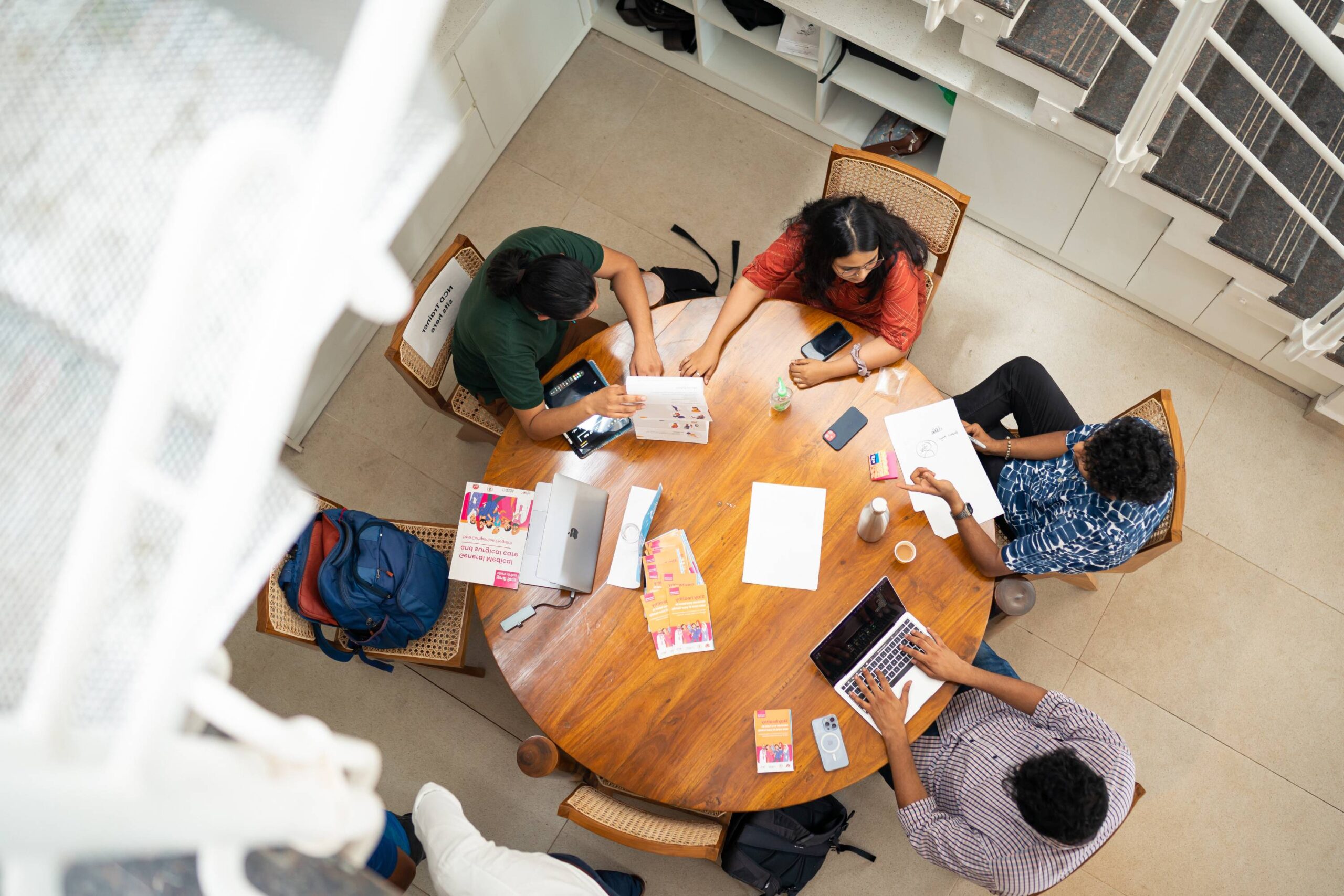 op view of Noora Health teammates working together around a table at the Bangalore office